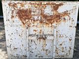 an old rusty refrigerator sitting in a parking lot with trees in the background