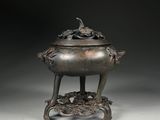 an image of a bronze incense pot on a stand on a white surface