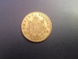 a close up of a gold coin on a black surface