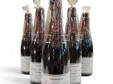 six bouteilles de vin sont alignées sur une surface blanche