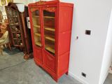 une armoire rouge avec une porte vitrée dans une pièce