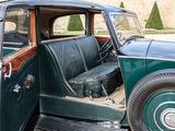 a green car that is parked in the driveway