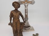 a statue of a woman holding a cross next to a crucifix