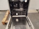 a dishwasher in the middle of the floor with a tray in it