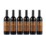 six bottles of red wine lined up on a white surface