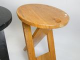 deux petits tabourets en bois placés l'un à côté de l'autre sur une surface blanche