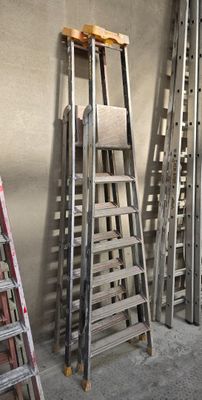 plusieurs échelles appuyées contre un mur dans une pièce