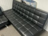 un canapé en cuir noir et un fauteuil dans un salon