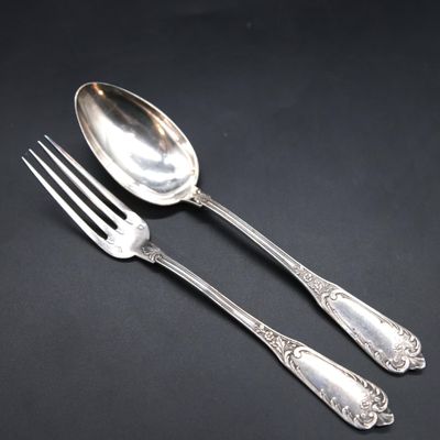 two spoons and a fork on a black surface