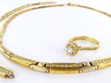 un collier, un bracelet et une bague en or sertis de diamants, sur fond blanc