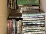 une boîte remplie de livres empilés les uns sur les autres