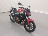 une moto rouge et blanche garée dans une pièce