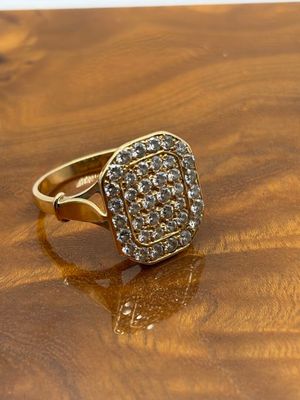 un gros plan d'une bague en or sertie de diamants posée sur une surface en bois