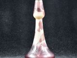 a glass vase that is sitting on a black surface