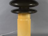 a black and yellow table lamp with a white cord on top of it