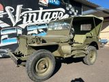 une vieille jeep militaire garée devant un immeuble