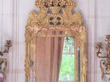 a mirror on a mantle with vases and a vase on it