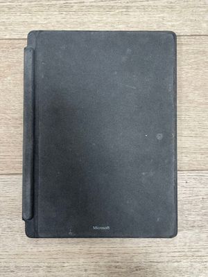 un cahier noir ouvert posé sur une table en bois
