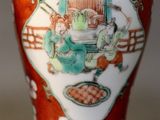 a red vase with a picture of a man and a woman on it