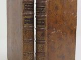 an old pair of books sitting next to each other on a white surface