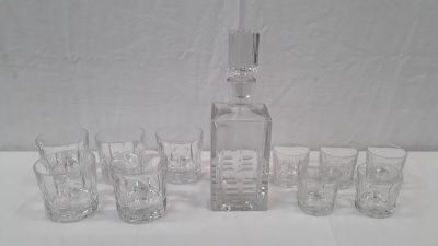 des bouteilles et des verres sont alignés sur une table à fond blanc