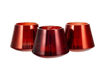 trois vases en verre rouge posés les uns à côté des autres sur une surface blanche