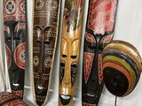 cinq masques en bois exposés sur un fond blanc