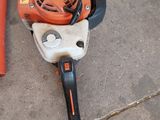 a chainsaw that is laying on the ground next to a pole