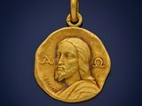 a close up of a gold coin with a jesus face on it