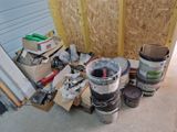 many buckets of paint sitting on the floor in front of a building