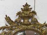 a mirror hanging on the wall with a gold frame