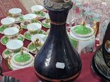 a lamp that is on a table with many cups and saucers