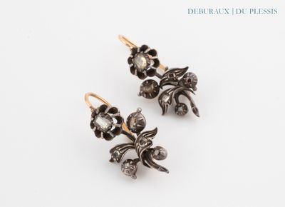 a pair of earrings with flowers and leaves on them