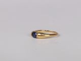 a close up of a gold ring with a blue stone on it