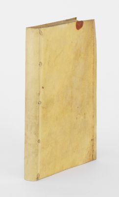 un vieux livre à la couverture brune posé sur une surface blanche
