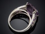 an amethorate and diamond ring on a black surface