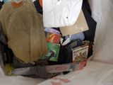 a bag full of clothes and other items on a bed