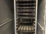 a metal rack with many trays of food in it