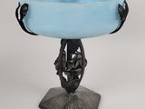 un bol en verre bleu posé sur un socle en métal