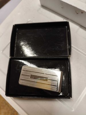 un porte-billets en argent dans un coffret noir posé sur une table