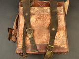 an old leather bag with two straps hanging from it ' s side