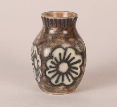a brown vase with black and white flowers on it