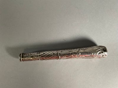 un gros plan d'un stylo posé sur une table, sur fond blanc