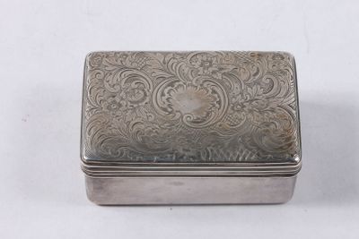 une vieille boîte en argent posée sur une surface blanche