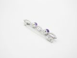 a close up of a pair of purple stones on a white surface