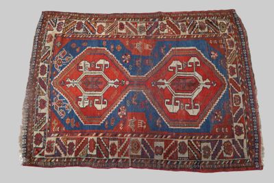 an old rug with a red and blue design on a white background