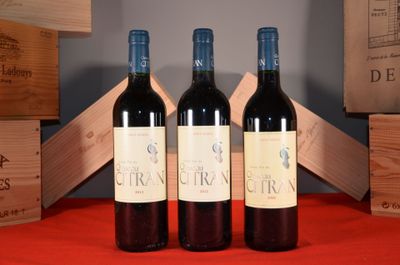 trois bouteilles de vin rouge posées sur une table