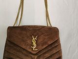 a brown handbag with a gold chain hanging from it