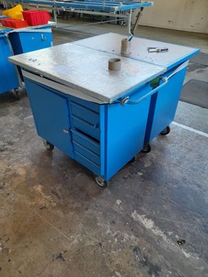a blue table with a machine on it in a warehouse