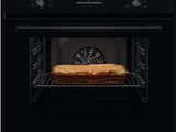 la porte du four est ouverte et il y a une miche de pain à l'intérieur